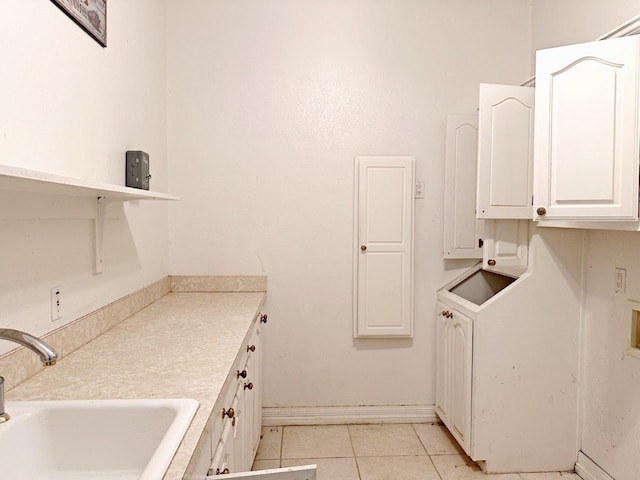 kitchen featuring sink, light tile floors, and white cabinets