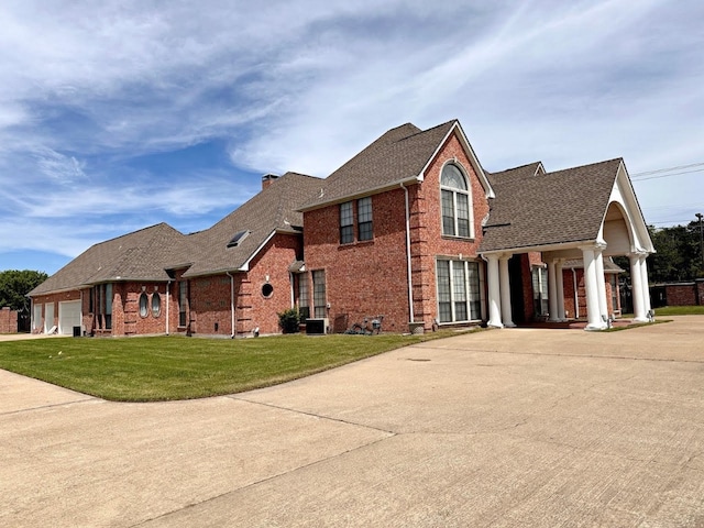 view of front of home featuring a front lawn and central AC