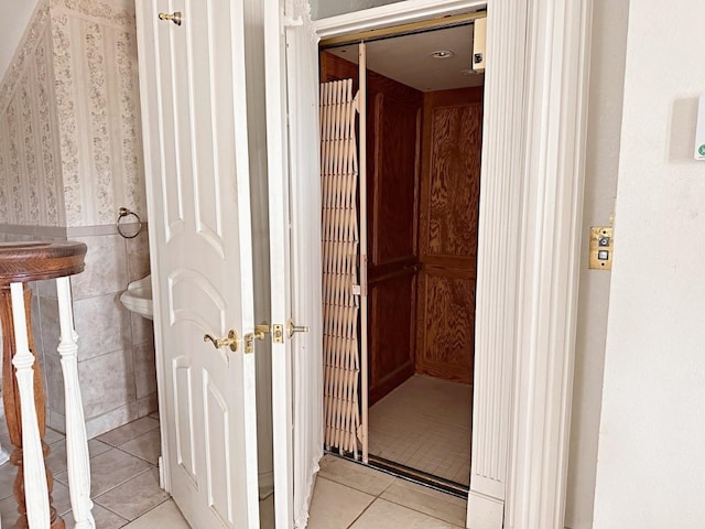 hallway with light tile floors and elevator