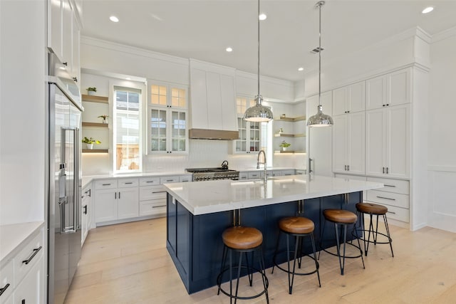 kitchen featuring light wood-type flooring, a breakfast bar area, a kitchen island with sink, and sink