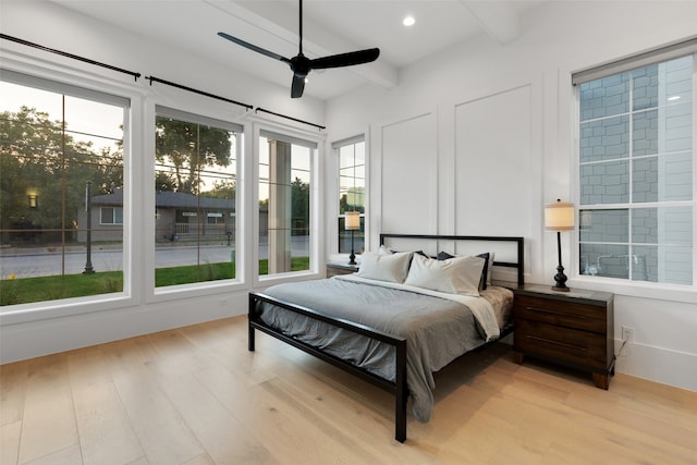 bedroom with light wood-type flooring, beam ceiling, and ceiling fan