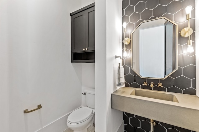 bathroom featuring backsplash, sink, and toilet