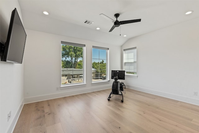 exercise room featuring light wood-type flooring, vaulted ceiling, and ceiling fan