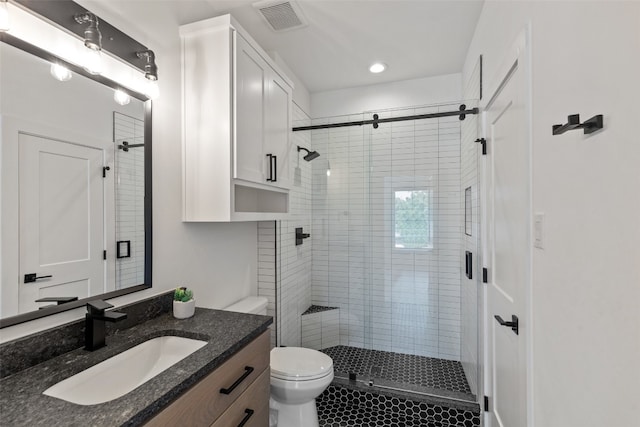 bathroom featuring walk in shower, vanity, toilet, and tile patterned floors