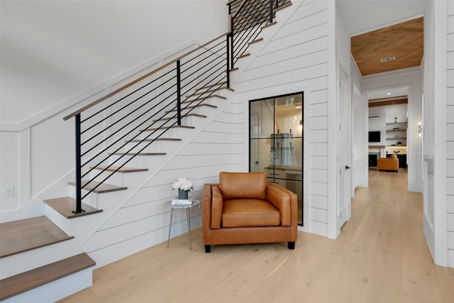 stairway featuring wood walls and hardwood / wood-style floors