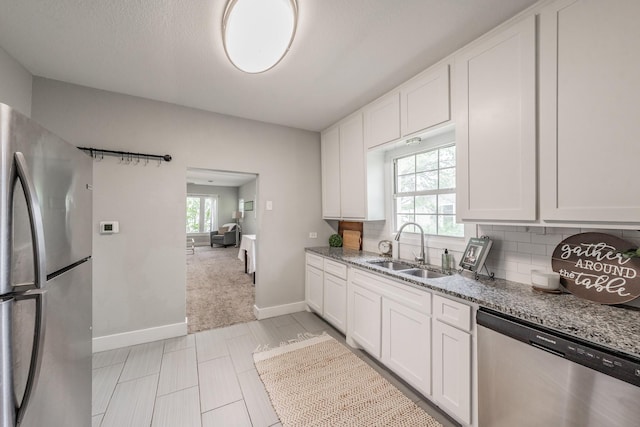 kitchen featuring light stone counters, sink, white cabinets, and appliances with stainless steel finishes