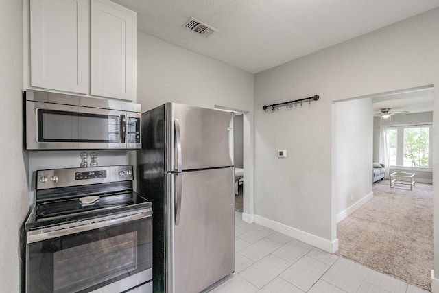 kitchen featuring white cabinetry, ceiling fan, stainless steel appliances, and light tile patterned floors