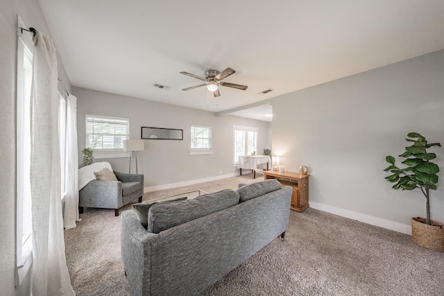 living room with ceiling fan and carpet