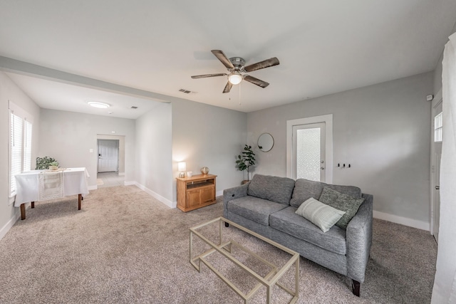 carpeted living room with ceiling fan