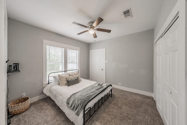 bedroom featuring dark colored carpet, ceiling fan, and a closet