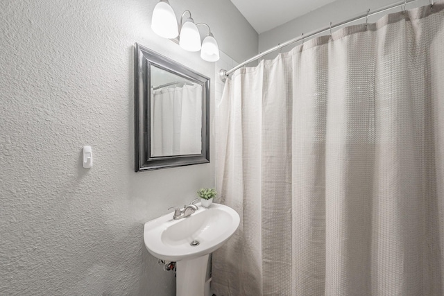 bathroom with walk in shower and sink