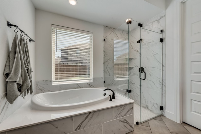 bathroom with tile flooring, a wealth of natural light, and independent shower and bath