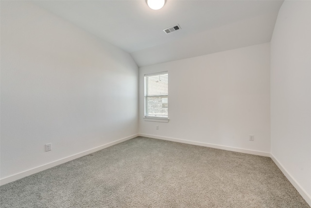 carpeted spare room with lofted ceiling