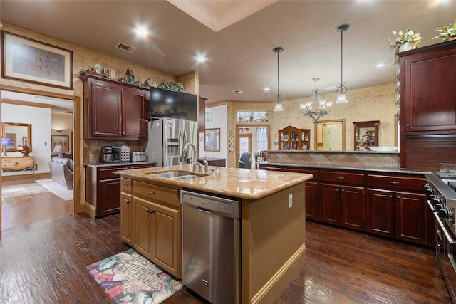 kitchen featuring a center island with sink, stainless steel appliances, backsplash, dark hardwood / wood-style flooring, and sink