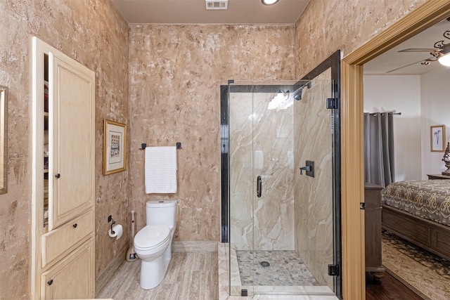 bathroom featuring toilet, ceiling fan, and an enclosed shower