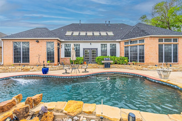 view of swimming pool featuring a patio area and grilling area