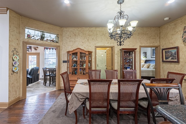 dining space with dark hardwood / wood-style floors and a notable chandelier