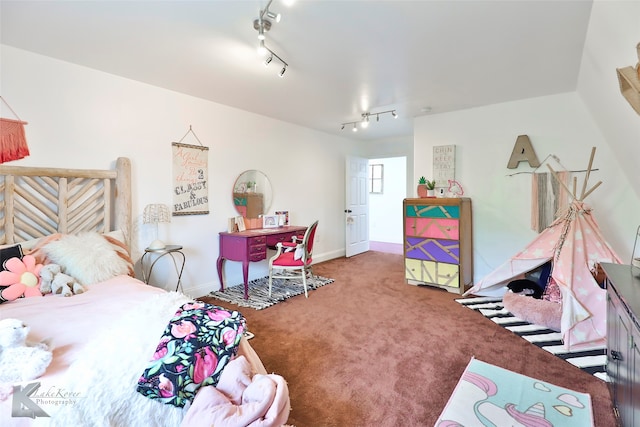 carpeted bedroom featuring track lighting