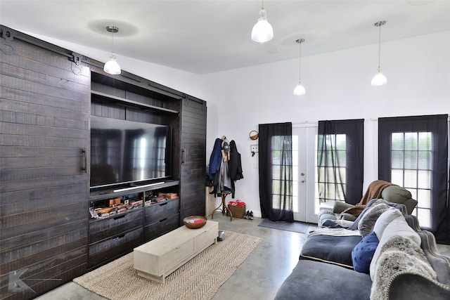 living room with french doors and concrete flooring