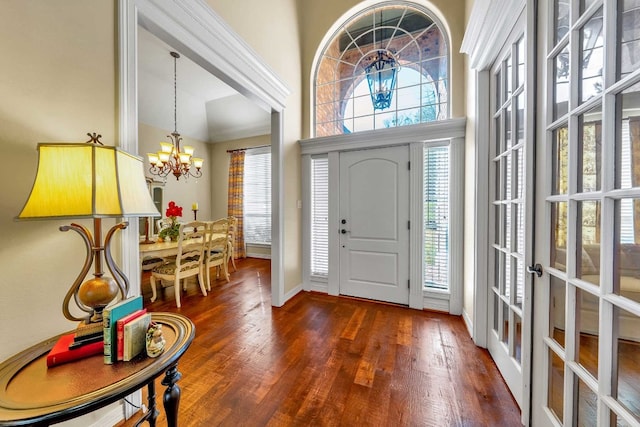 foyer featuring a chandelier, plenty of natural light, and dark wood-type flooring