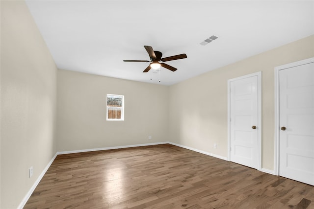 interior space featuring ceiling fan, two closets, and dark hardwood / wood-style floors