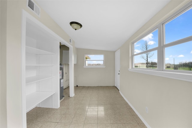 hall featuring vaulted ceiling and light tile floors