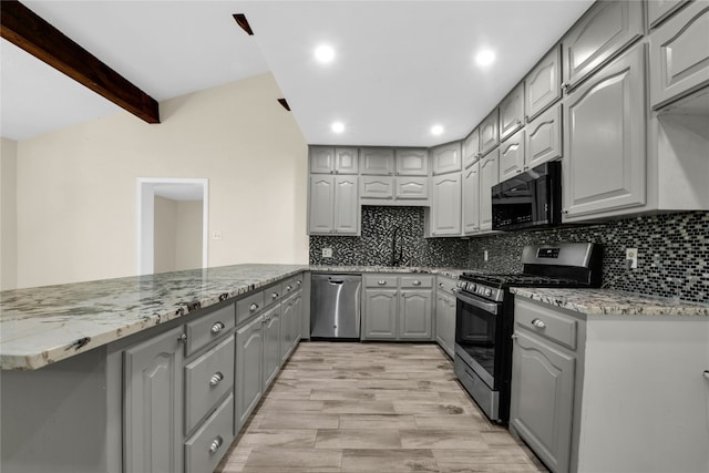 kitchen with light stone countertops, appliances with stainless steel finishes, light hardwood / wood-style flooring, tasteful backsplash, and gray cabinets