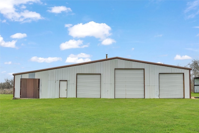 view of shed / structure with a garage and a yard