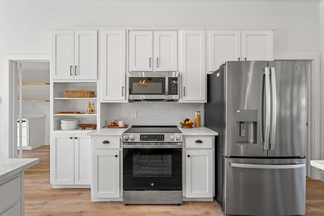 kitchen featuring white cabinets, decorative backsplash, light hardwood / wood-style floors, and appliances with stainless steel finishes