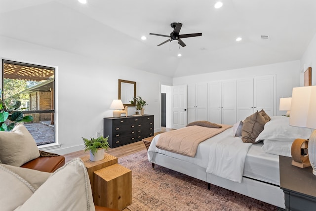 bedroom featuring hardwood / wood-style floors, a closet, ceiling fan, and lofted ceiling