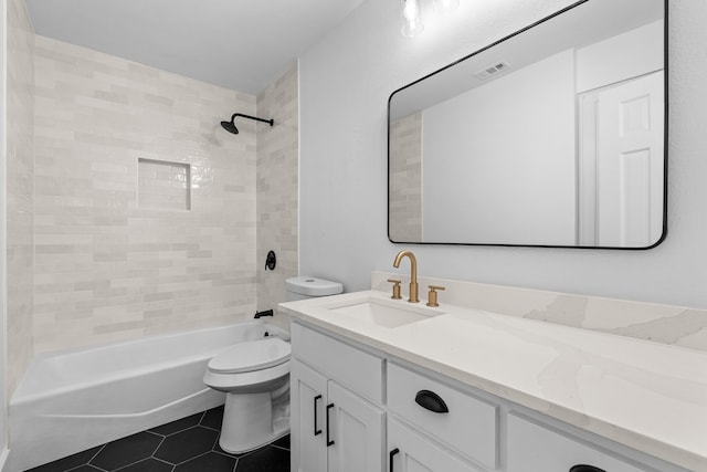 full bathroom featuring tile patterned flooring, vanity, tiled shower / bath combo, and toilet