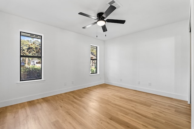 empty room featuring light hardwood / wood-style flooring, ceiling fan, and a healthy amount of sunlight