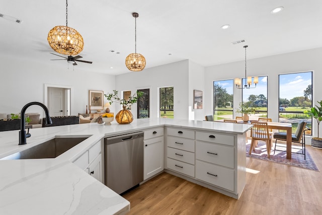 kitchen featuring dishwasher, sink, hanging light fixtures, light hardwood / wood-style flooring, and white cabinets