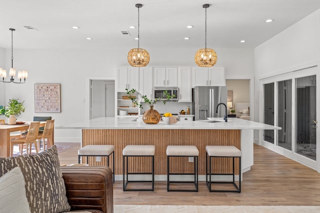 kitchen featuring white cabinets, a kitchen breakfast bar, a spacious island, and stainless steel appliances