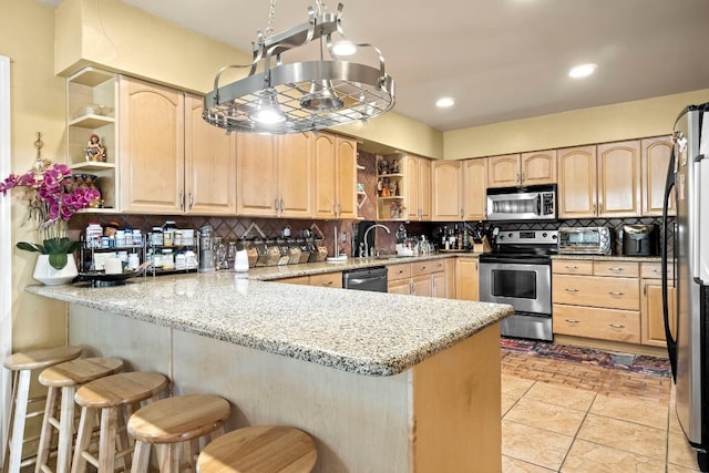 kitchen featuring appliances with stainless steel finishes, backsplash, a kitchen bar, light tile floors, and light stone countertops