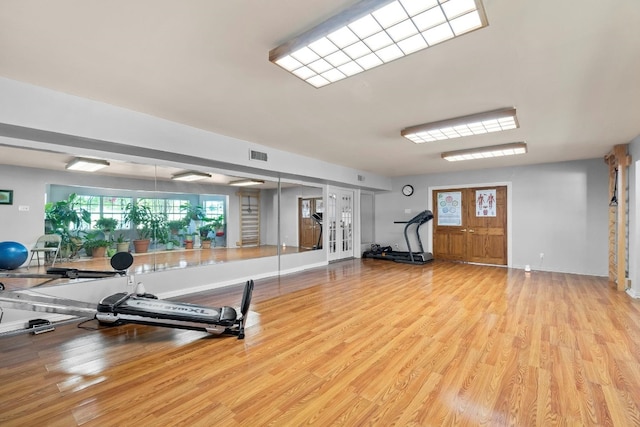 workout area featuring light hardwood / wood-style floors and french doors