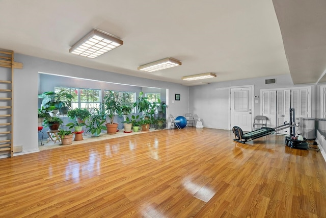 workout area with light hardwood / wood-style floors