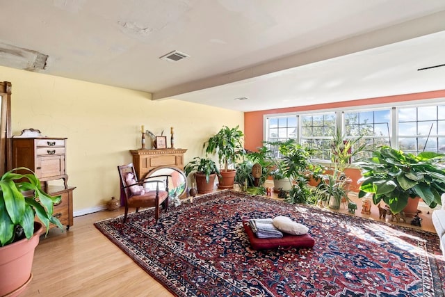 sitting room with beam ceiling and light wood-type flooring