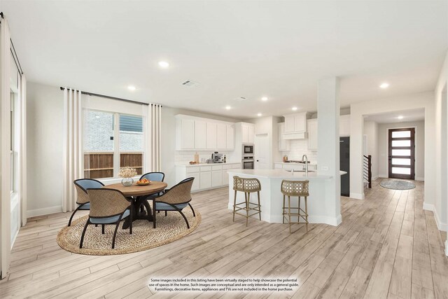 dining room featuring light wood-type flooring, baseboards, and recessed lighting