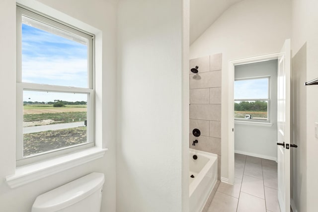 full bath featuring lofted ceiling, toilet,  shower combination, tile patterned flooring, and baseboards