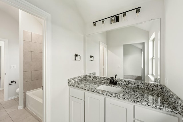 full bathroom featuring toilet, tile patterned floors, vanity, vaulted ceiling, and a tub