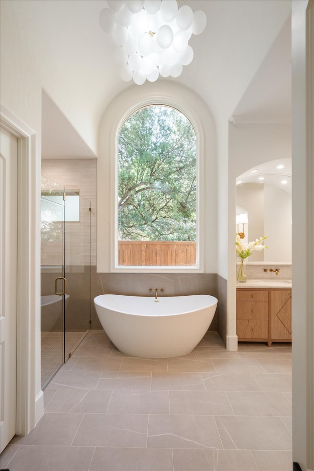 bathroom with independent shower and bath, vanity, a chandelier, and tile patterned flooring