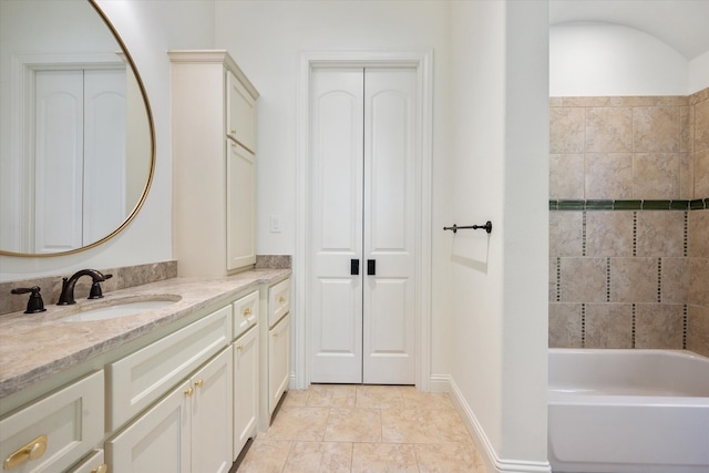 bathroom with vanity, tile patterned floors, and a tub