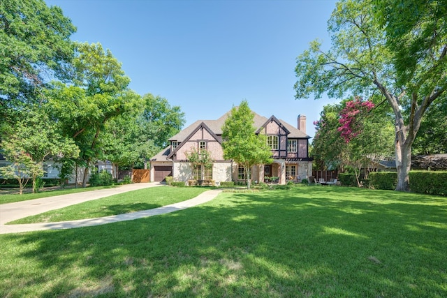 tudor house with a garage and a front yard