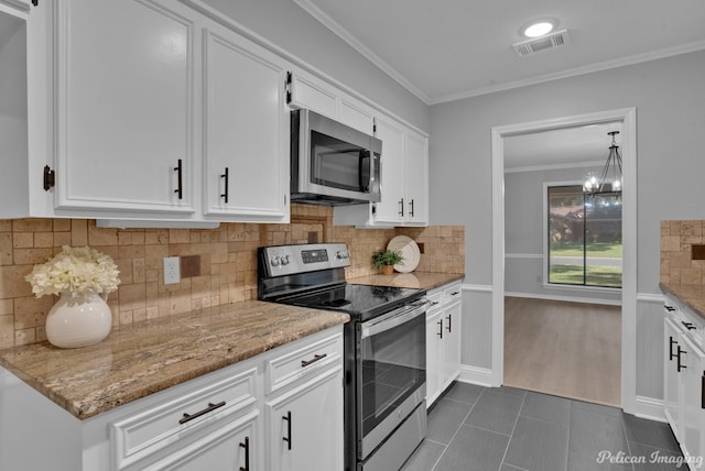 kitchen featuring stainless steel appliances, ornamental molding, white cabinets, and light stone counters