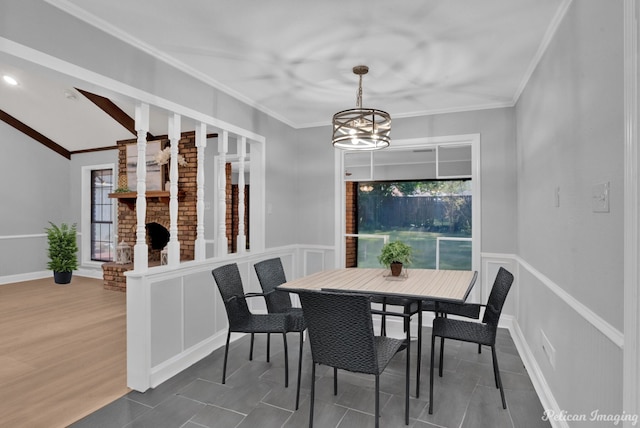 dining room with crown molding, wood-type flooring, vaulted ceiling, and a notable chandelier