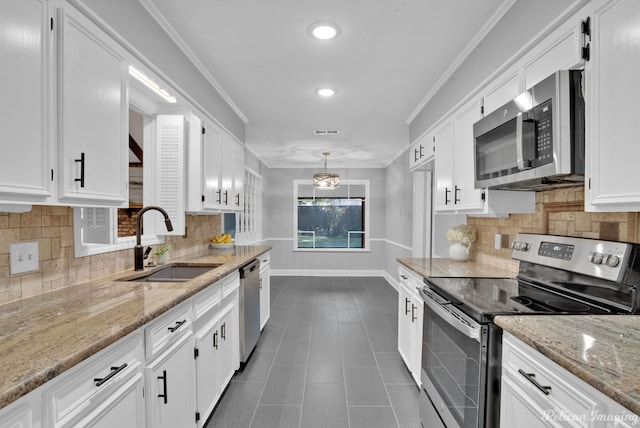 kitchen with sink, appliances with stainless steel finishes, pendant lighting, light stone countertops, and white cabinets