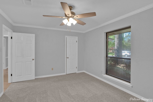 empty room with ornamental molding, light colored carpet, and ceiling fan