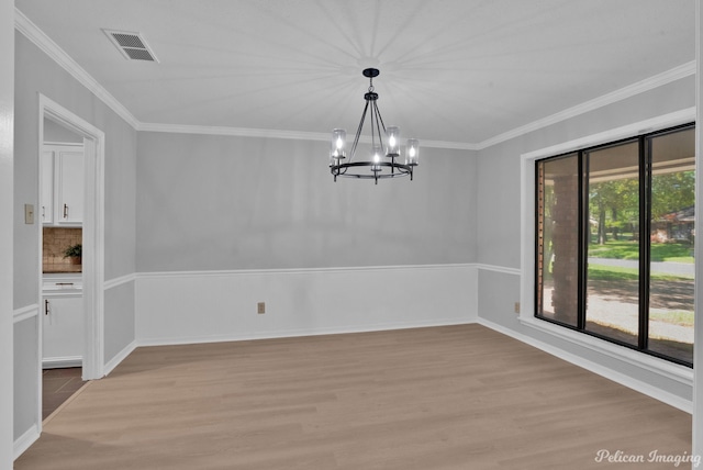 unfurnished dining area with crown molding, light hardwood / wood-style floors, and a notable chandelier