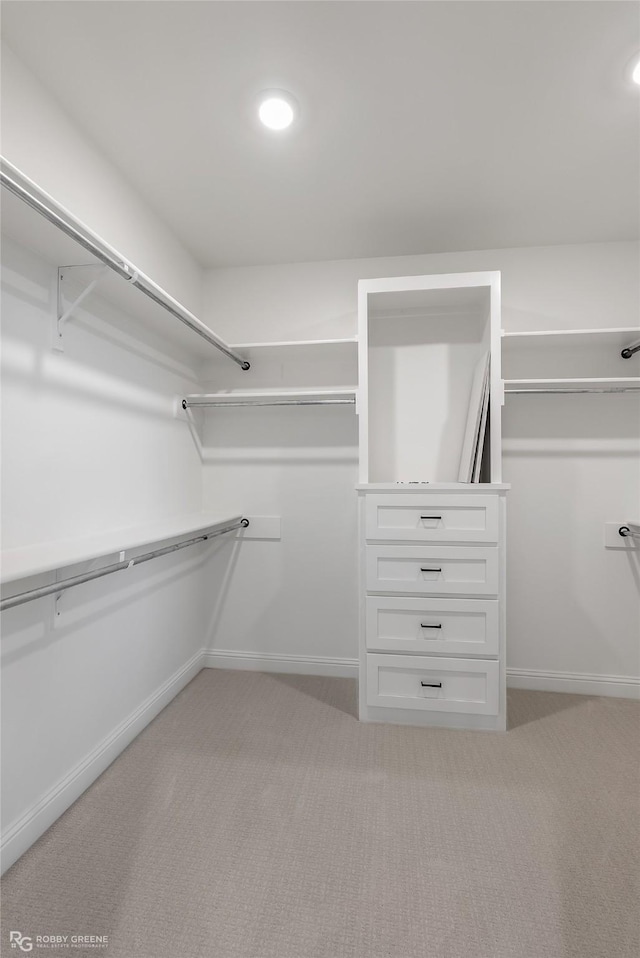 walk in closet featuring light colored carpet